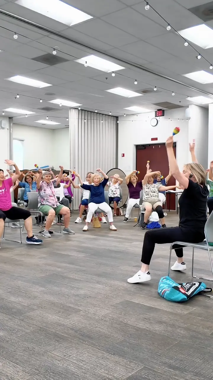 Participants dancing seated in chairs